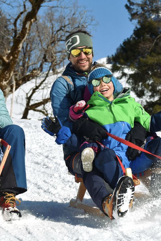 Familienspaß beim Rodeln von der Schwarzenberghütte im Naturschutzgebiet im Hintersteiner Tal.