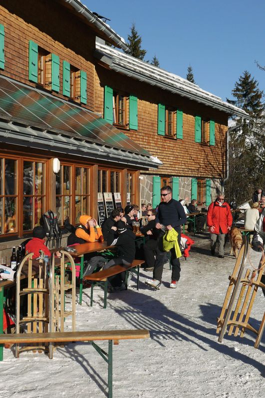 Verschneite Schwarzenberghütte: Idyllische Berghütte im winterlichen Hintersteiner Tal bei Bad Hindelang, umgeben von schneebedeckten Bergen.